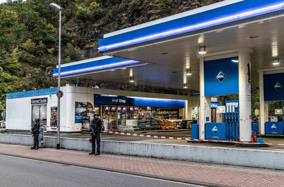 Polizisten sichern am frühen Morgen eine Tankstelle, in der am Vortag ein  49-Jähriger einem 20 Jahre alten Kassierer in den Kopf geschossen hatte.