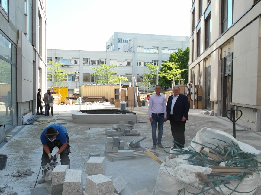 Projektleiter Carsten Teltscher (links) und BBG-Geschäftsführer Rainer Ganske zeigen, wo es künftig zwschen den beiden Gebäuden des Pulse-Neubaus einen Fußweg von der Olgastraße zur Wolfgang-Brumme-Alle geben wird. Bild: Staber