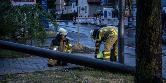 Feuerwehrleute zersägen den Holzmasten.