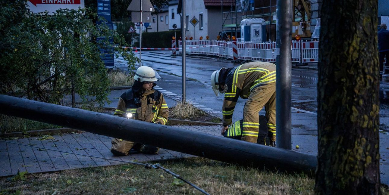 Feuerwehrleute zersägen den Holzmasten.