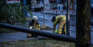 Feuerwehrleute zersägen in Maichingen einen Holzmasten.