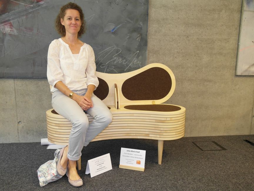 Julia-Marie Ruß auf ihrem "Tisch-Bänklein - Kommunikationsmöbel in Ahorn und Nussbaum".