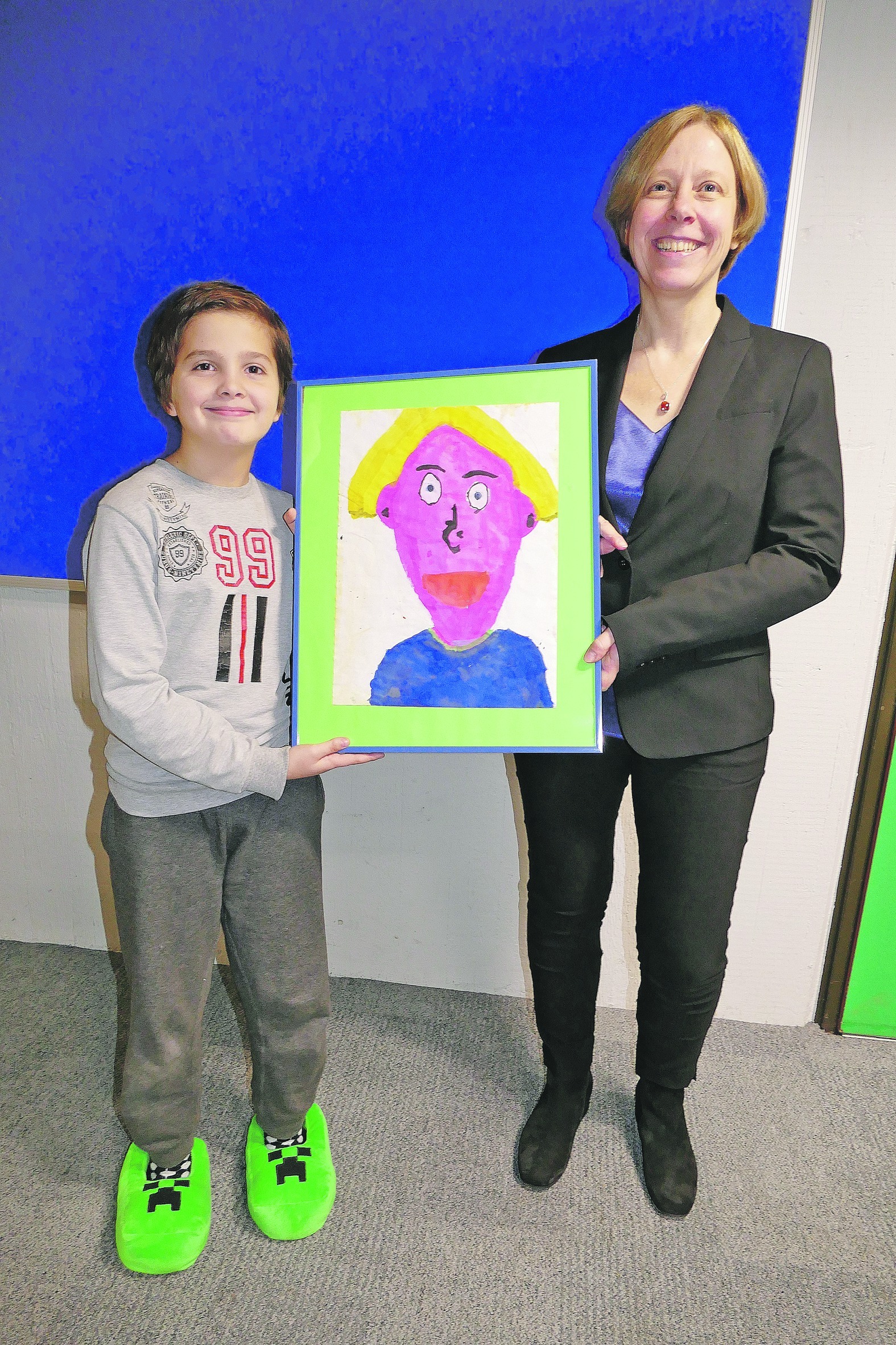 Christian aus der 4. Klasse, die Simone Röhm unterrichtet, zeigt sein Siegerbild für die Einladung zur Einsetzung der neuen Rektorin. Bild: Lück
