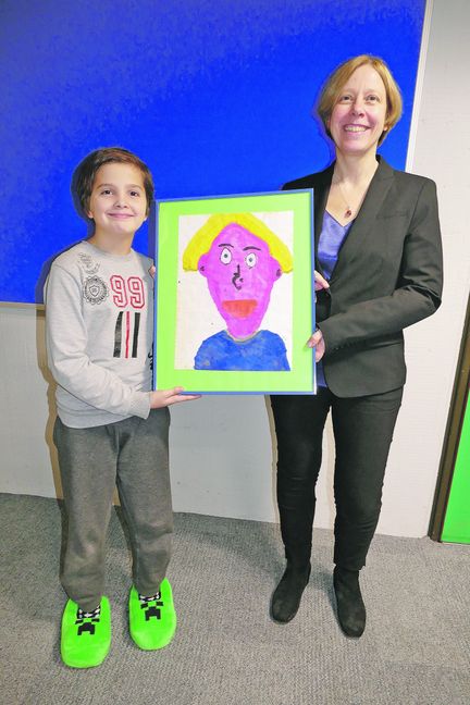 Christian aus der 4. Klasse, die Simone Röhm unterrichtet, zeigt sein Siegerbild für die Einladung zur Einsetzung der neuen Rektorin. Bild: Lück