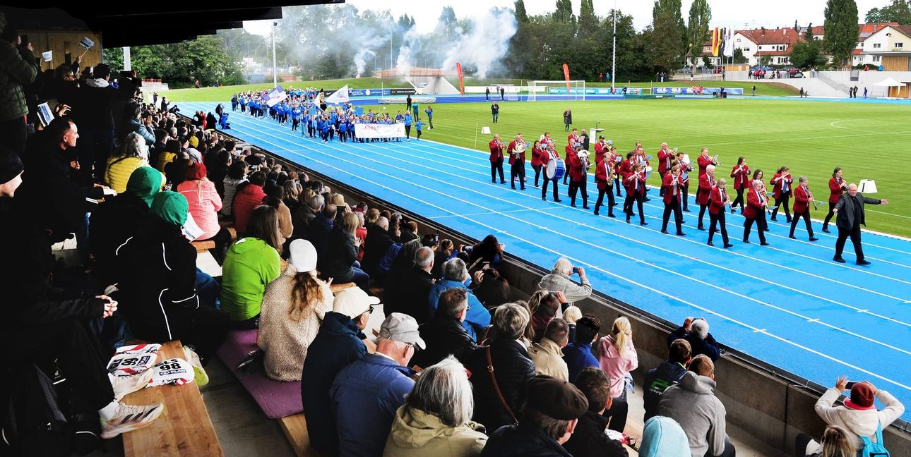 Timo Kächele und die Stadtkapelle führen die Sportler ins sanierte Stadion.