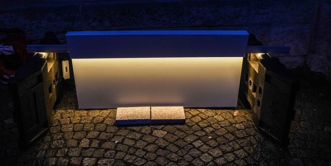 Ein Lichtband strahlt auf zwei Platten, die künftig auf dem Marktplatz liegen sollen.