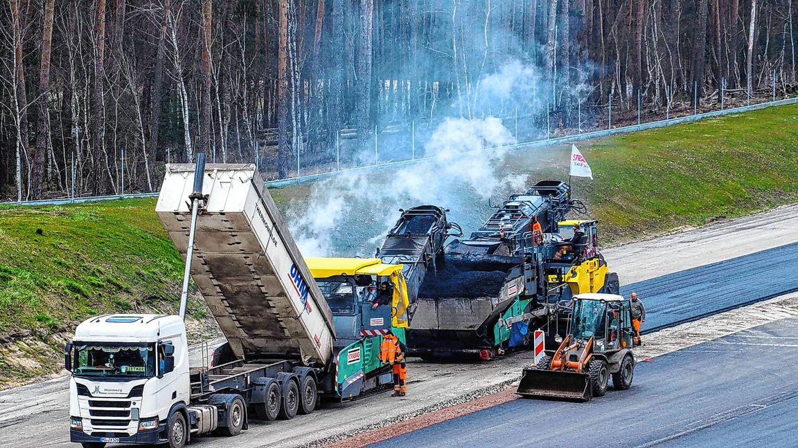 Arbeiter asphaltieren neue Abschnitte der Autobahn 14.