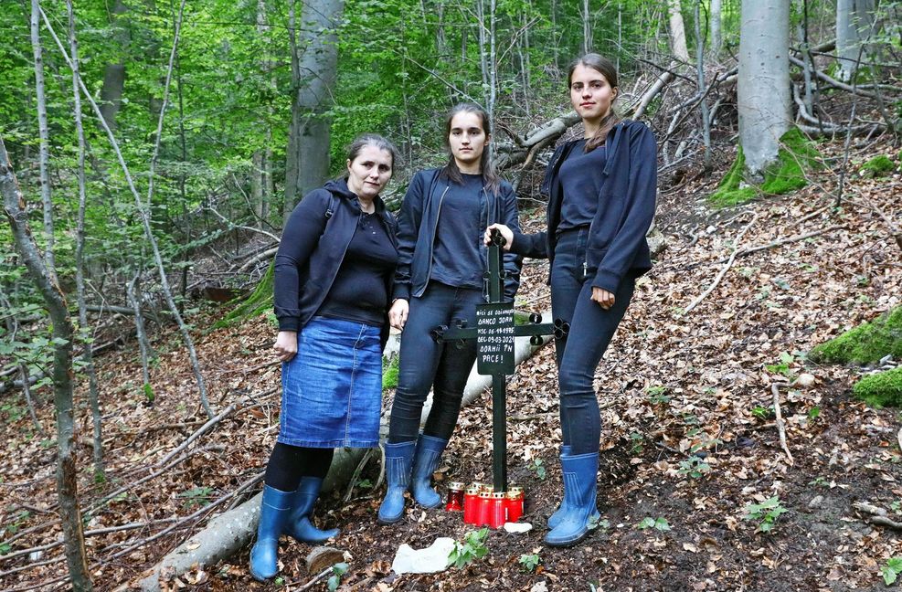 Ein Kreuz mit Inschrift hat die Witwe Motrea Danco zusammen mit ihren Töchtern Ana und Maria im Eninger Gemeindewald  aufgestellt. Es steht dort, wo ihr Mann von einem Ast erschlagen wurde.
 Foto: Horst Haas