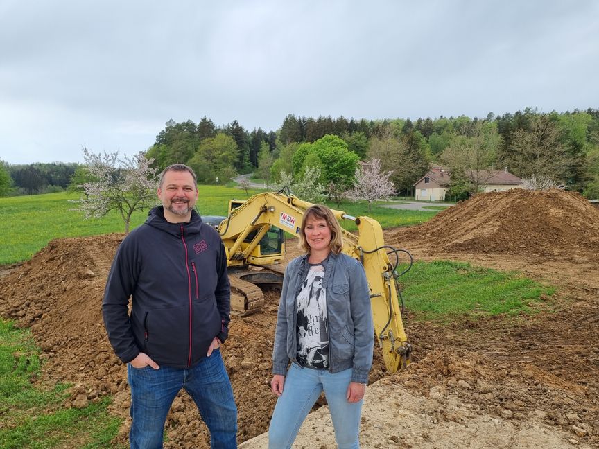 Marco Cartarius und Melanie Hahn stehen dort, wo zurzeit  mit Baggern ein Dirt-Park  gebaut wird, auf einem Erdhügel. Im Hintergrund befindet sich das Waldstück, in dem nächstes Jahr Mountainbike-Trails eingeweiht werden sollen. Bild: Hamann´´