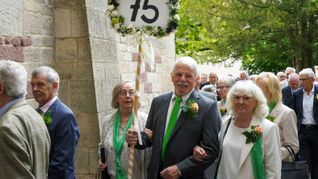 Willi Wolf reckt – sichtbar für alle – ein Schild mit der Zahl „75“ für den Jahrgang 1949 in die Höhe, als es in die Martinskirche geht.