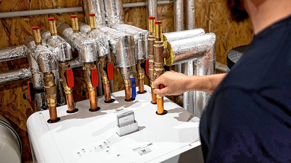 Ein Handwerker arbeitet an einer Wärmepumpe in der Enpal Akademie.