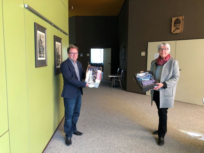 Christa Babel, stellvertretende Vorsitzende der Maichinger Landfrauen übergibt die Masken an Ortsvorsteher Wolfgang Stierle,.