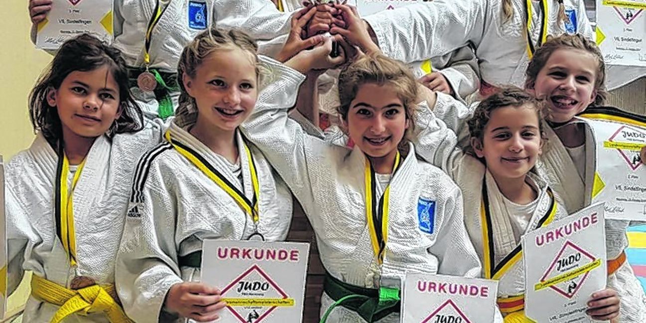 Neun Hände am Pokal: die erfolgreichen Judo-Mädchen des VfL Sindelfingen bei der Landesmeisterschaft in Backnang.  Bild: Vilz