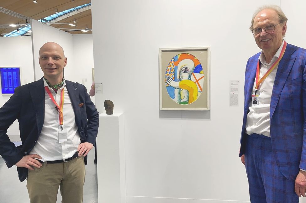 Kay Kromeier (links) und Dr. Bert Schlichtenmaier mit einer Arbeit von Horst Antes in ihrer Koje in den Messehallen von Rheinstetten.