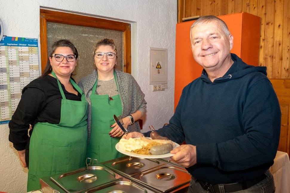 Roman Hamrik lässt sich die Schlachtplatte schmecken, die Adelina Haverl und Maria Meier ausgeschöpft haben.