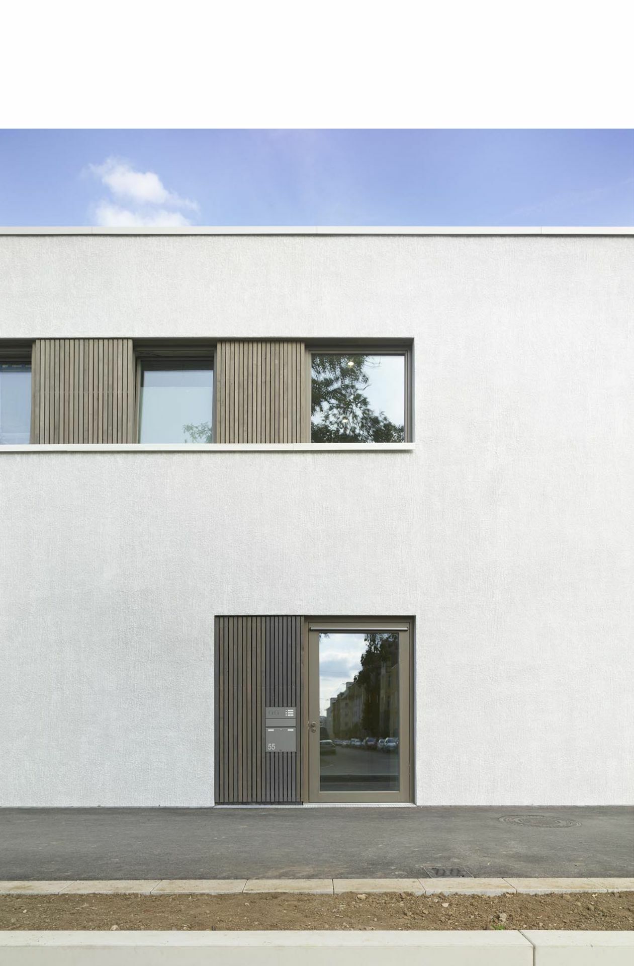 Grobkörniger Putz, grau lasierte Fensterläden und -rahmen.