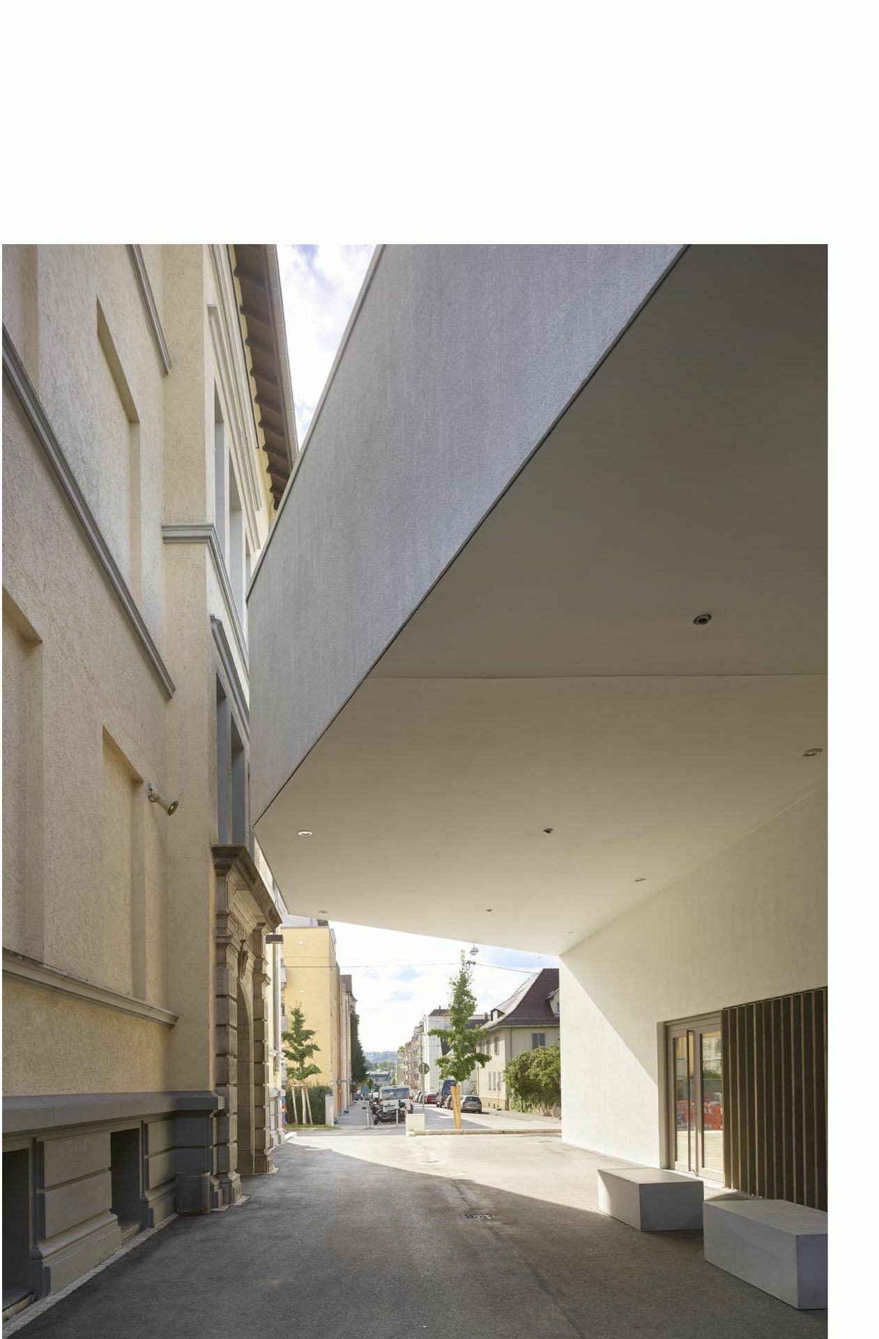 Annäherungen von Neu und Alt in  Bad Cannstatt: Das Dach des Neubaus, entworfen vom Stuttgarter Architekturbüro Harris+Kurrle, dockt an das Portal der Grundschule an. Die Schülerinnen und Schüler können also auch bei nassem Wetter trockenen Fußes in die Mensa und zurück.
