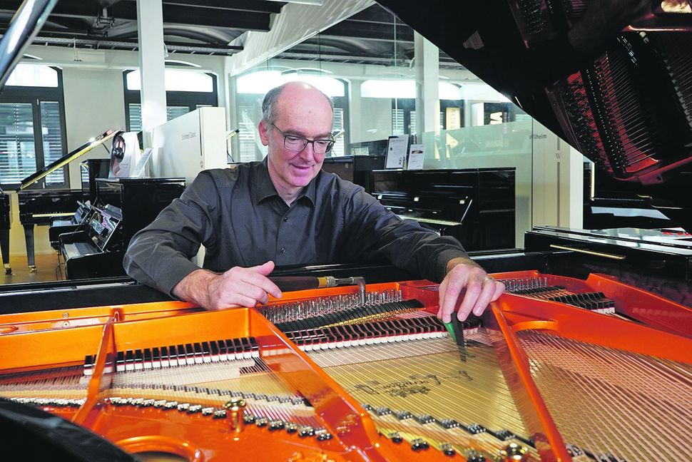 Wilhelm Hölzle beim Stimmen eines Flügels in den Geschäfts- und Ausstellungsräumen seines Pianohauses. Bild: Heiden