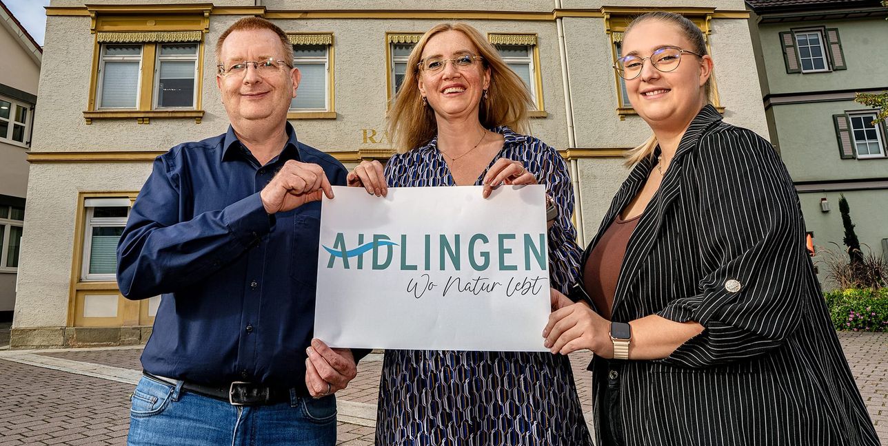 Vor dem Rathaus mit dem neuen Logo von links Hauptamtsleiter Timo Koch, Bürgermeisterin Helena Österle und Mitarbeiterin für Gemeinderat und Öffentlichkeitsarbeit Laura Peters. Bild: Richter