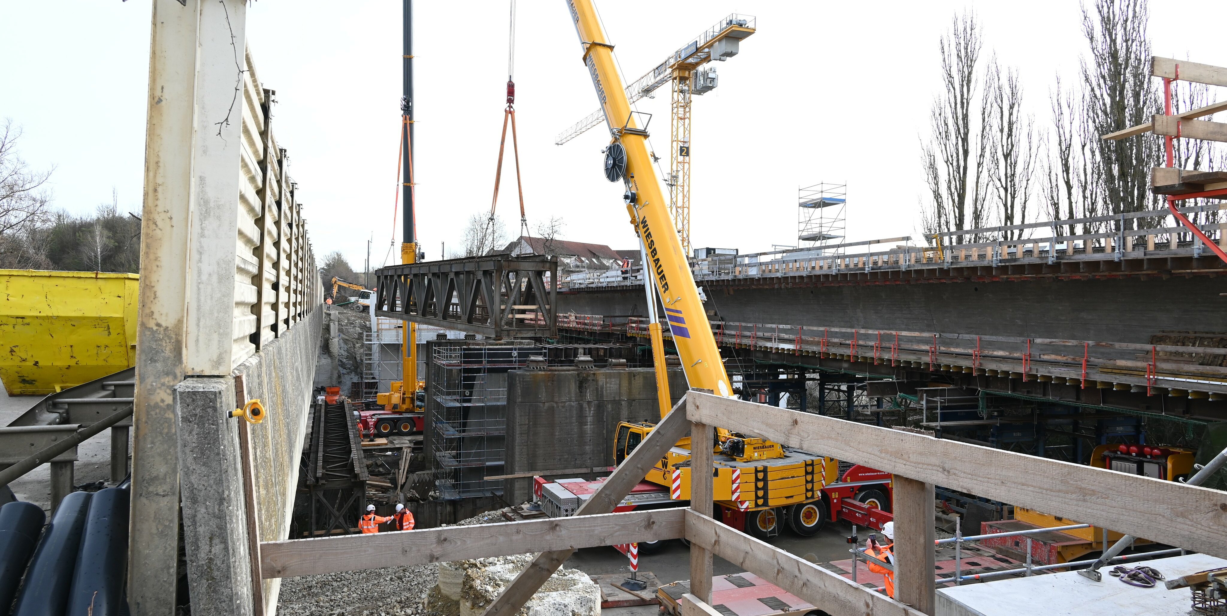 Schwerlastkräne heben die Teilstücke von den Brückenpfeilern.