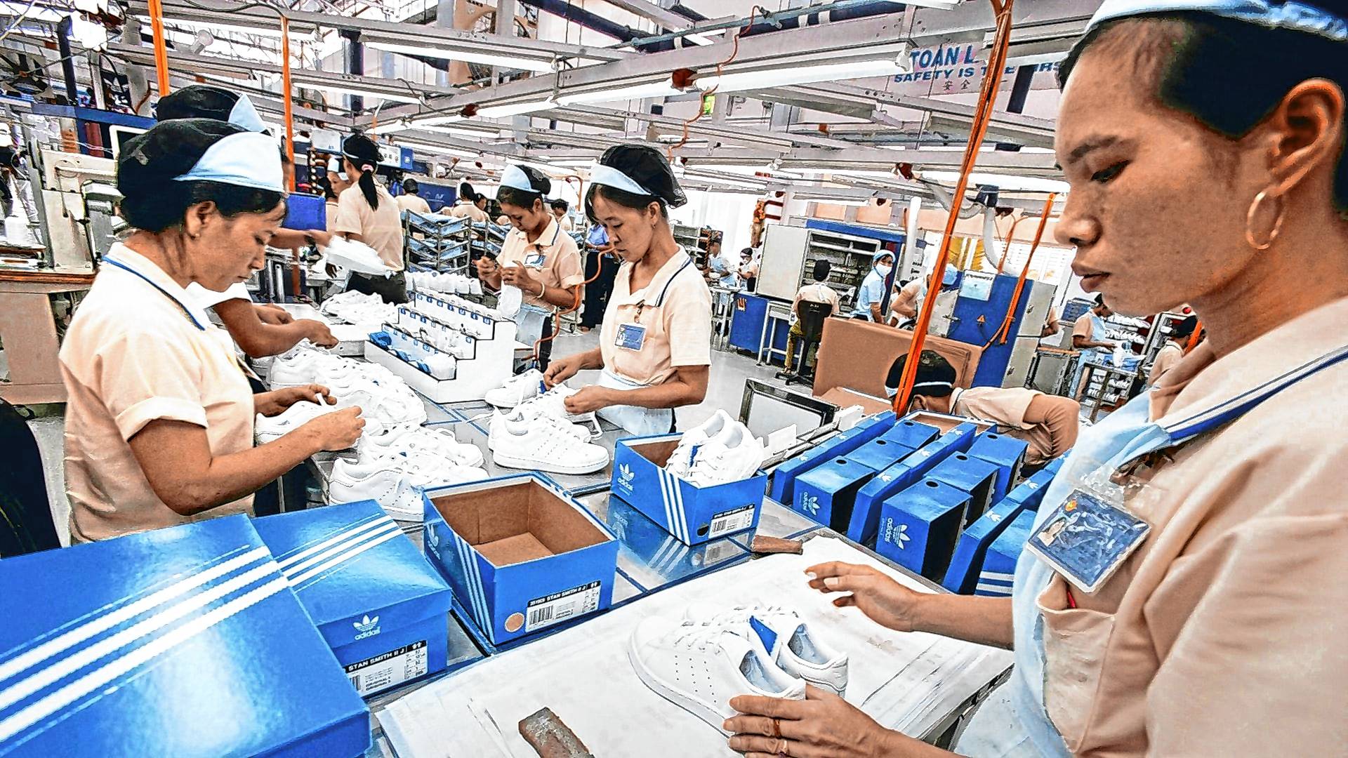 Arbeiterinnen in Phnom Penh stellen Schuhe für Adidas her.