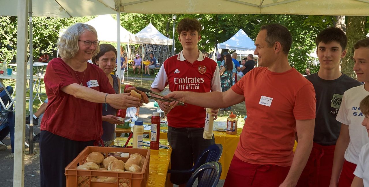 Viktor Rennich versorgt Marion Conzelmann mit Bratwurst.