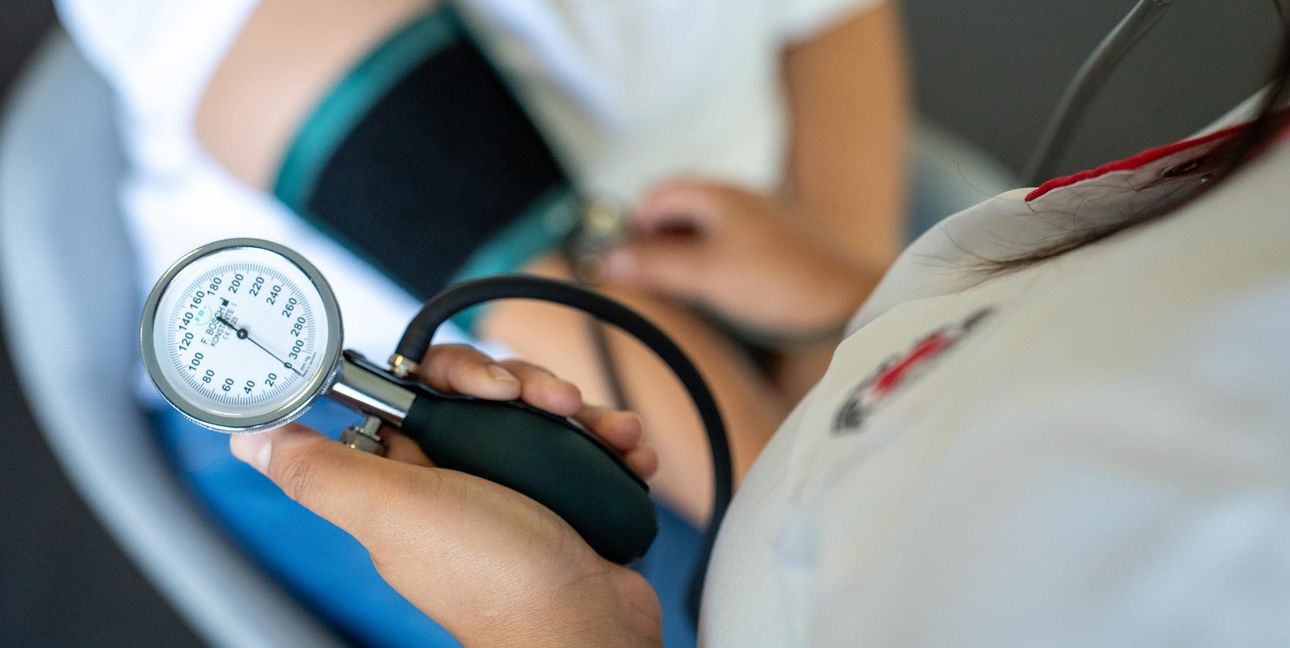 Eine Pflegerin misst den Blutdruck.