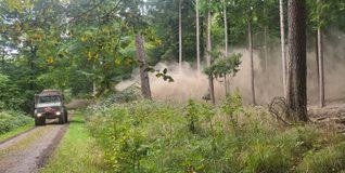 Kalkung in Aktion: Während der Unimog durch den Wald fährt, verteilt er eine feine Staubwolke aus Dolomitkalk und Holzasche über dem Waldboden.