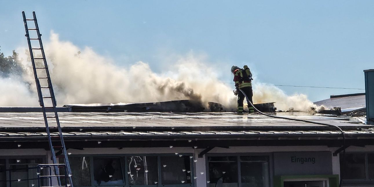 Die Feuerwehrleute versuchen das Feuer vom Dach aus zu löschen.