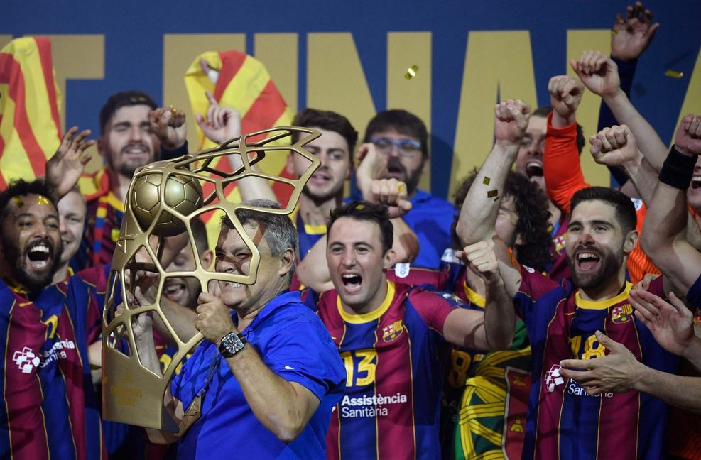 Trainer Xavier Pascual Fuertes jubelt mit der Champions-League-Trophäe und seiner Mannschaft.
 Foto: AFP/Ina Fassbender