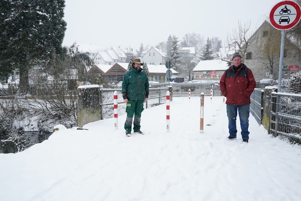 Geschäftsführer Volker Röhe (li) und Ulrich Lechner auf der verpollerten Schwippebrücke. Im Hintergrund Oskars Pflanzenmarkt.                                            Bild: Heiden