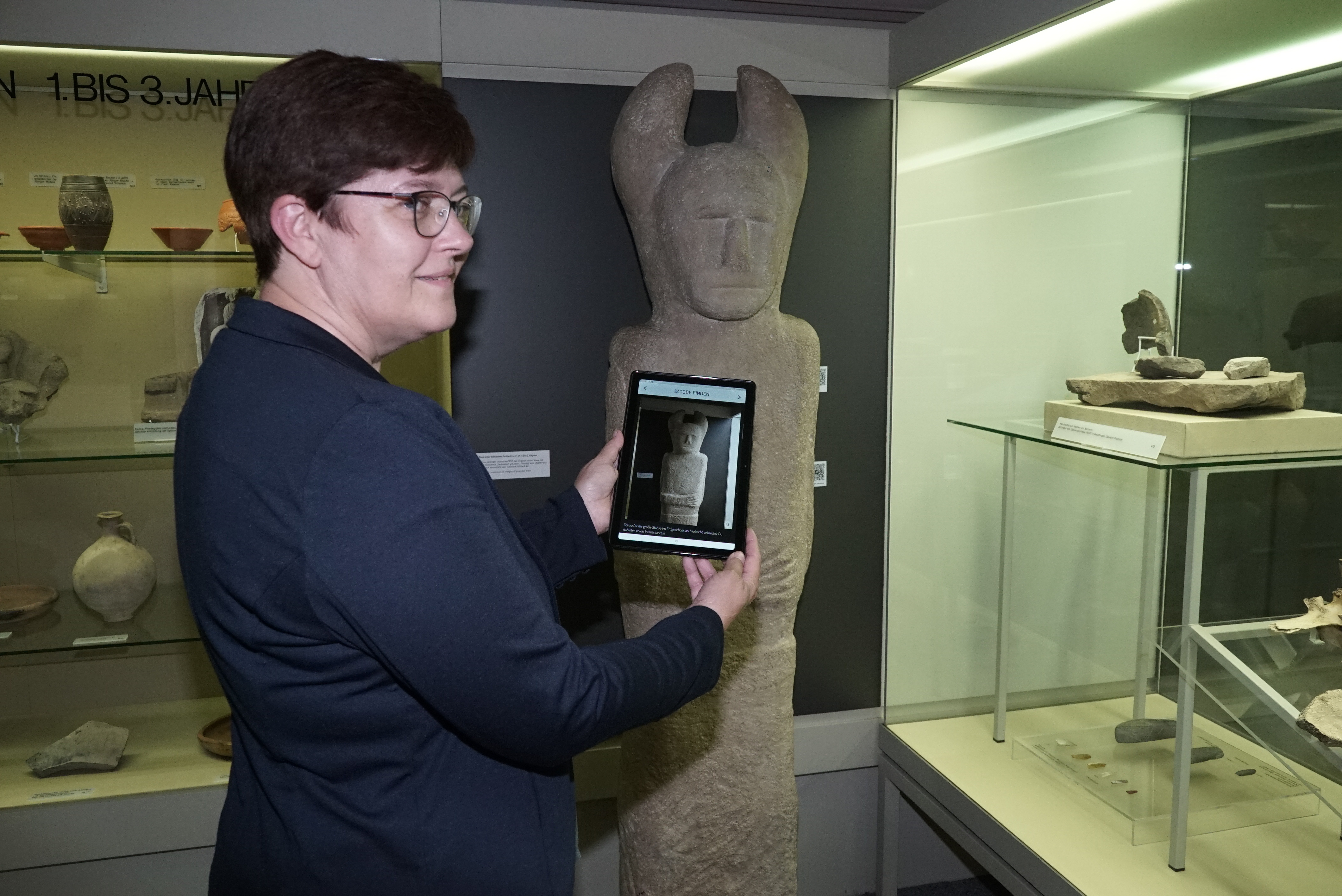 Stadtmuseumsleiterin Illja Widmann löst ihre Quizaufgabe natürlich mit Leichtigkeit: QR-Code an der Kelten-Stele  scannen.  Bild: Heiden