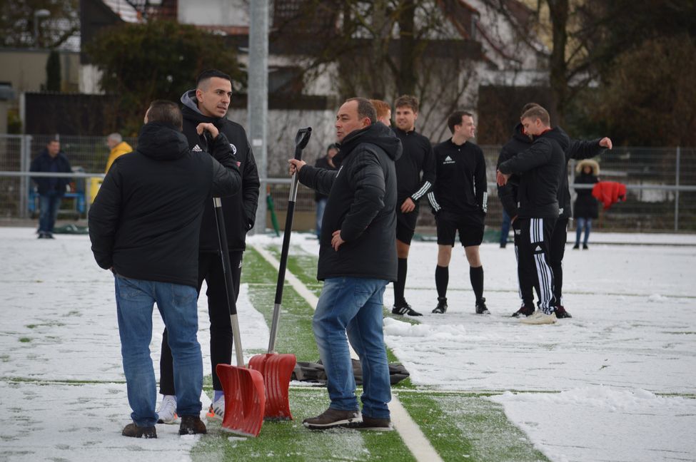 Winterdienst in der Rosenstrtaße: Im Vordergrund besprechen Ralf Kübler, Trainer Roberto Klug und Thomas Kübler id eLage (von links), hinten entscheidet Schiedsrichter Nico John, dass es doch noch etwas wird mit dem Verbandsliga-Duell.      Bild: Zvizdiç