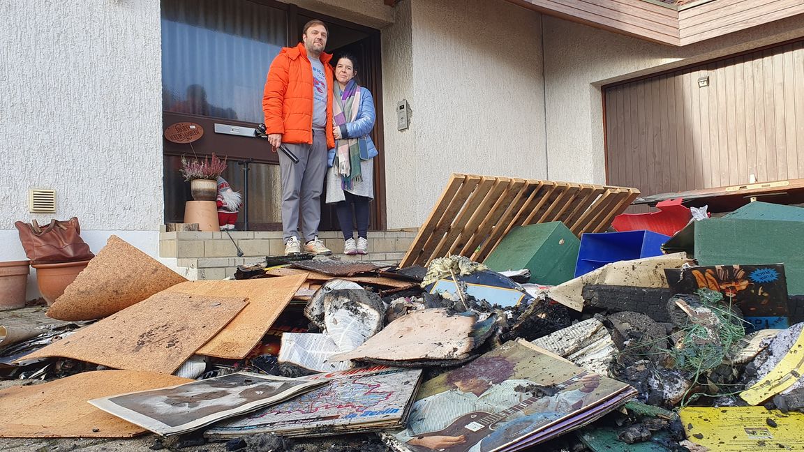 Julian und Alessandra Grumbach vor dem Brandgut, das die Feuerwehr aus dem Keller holte.    Bild: Wegner