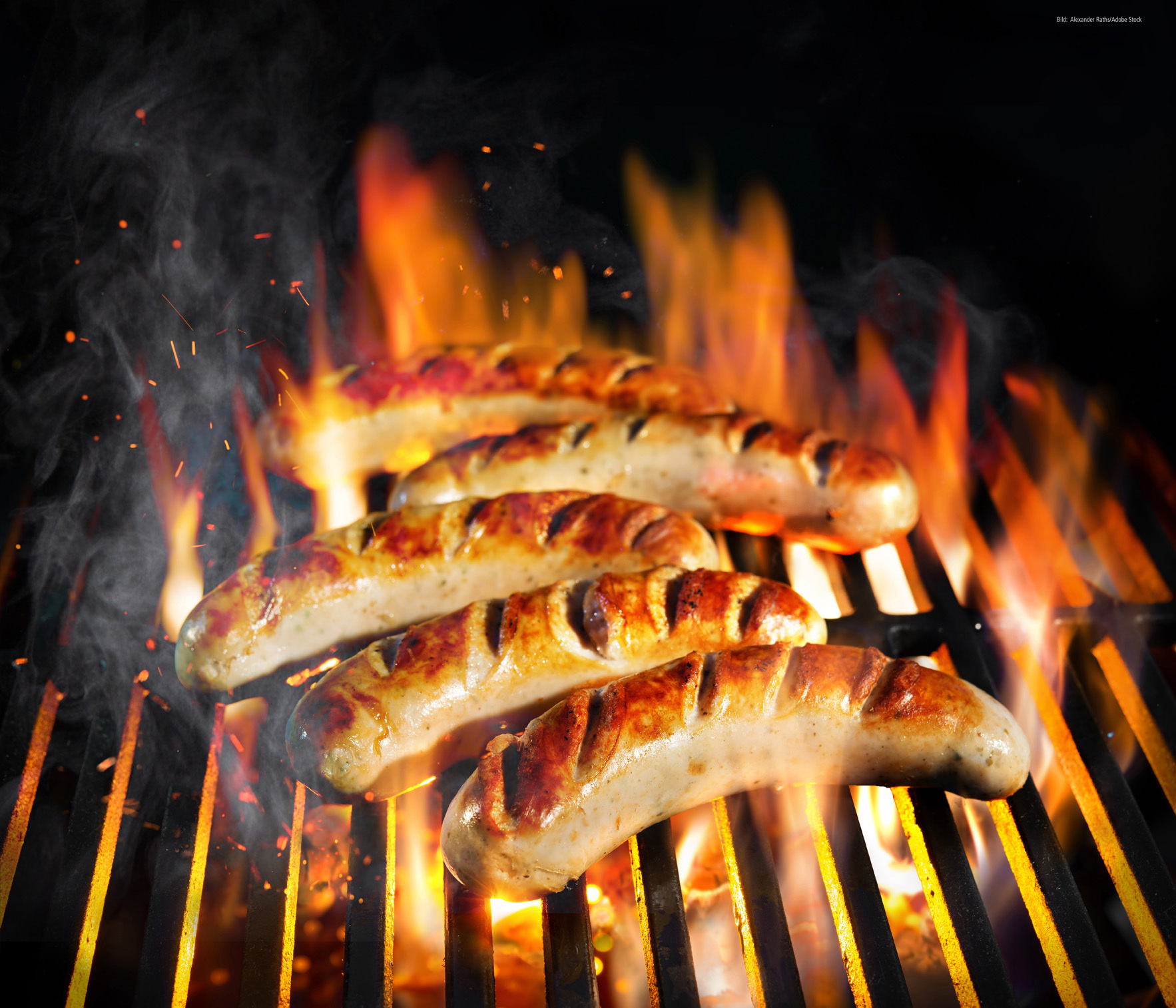 Grilled sausage on the flaming grill with smoke