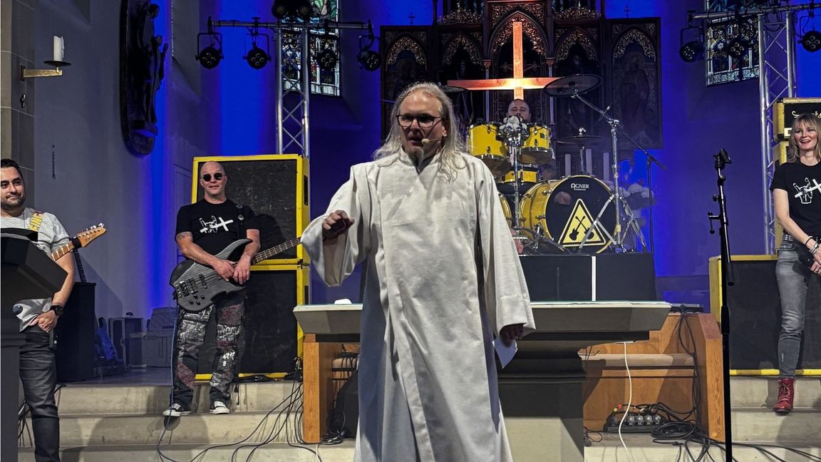 Während Mathias Fuchs in der Bruchsaler Kirche predigt, hält sich die Band „Metal Godz“ im Hintergrund bereit.