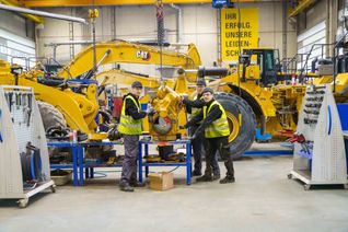 Die drei rumänischen Praktikanten Bogdan Szasz, Daniel Oproiu und Iosua Oltean (von links nach rechts) in der Werkstatt von Zeppelin Baumaschinen auf der Hulb. Zwei Wochen lang haben sie einen Einblick in verschiedene Bereiche erhalten.