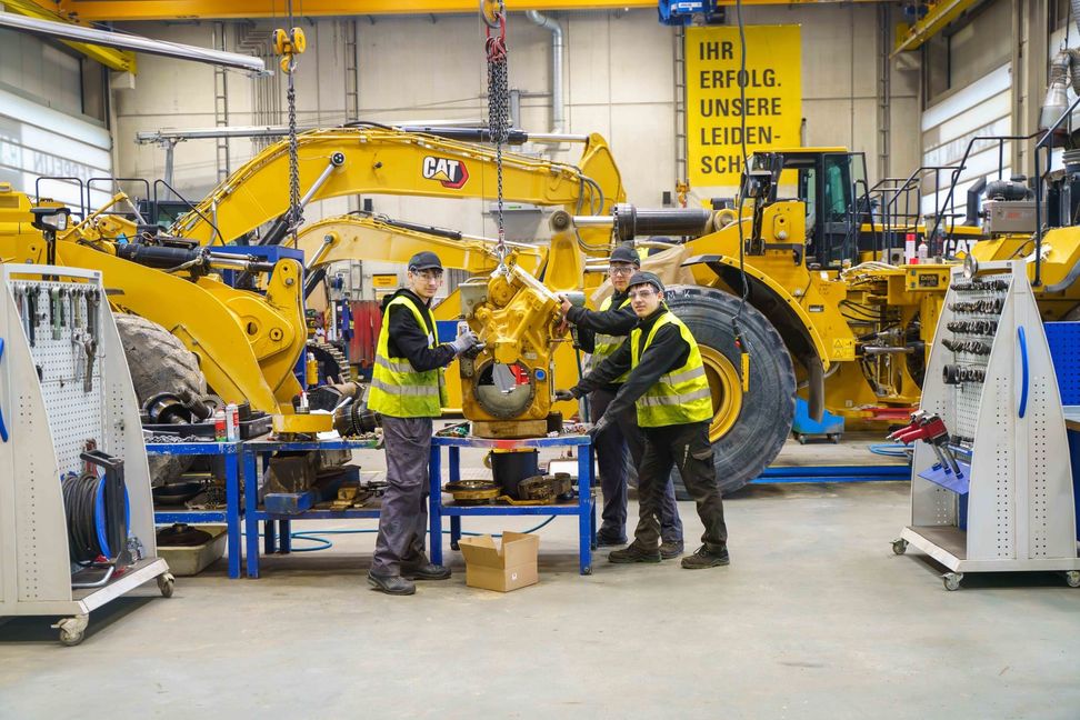 Die drei rumänischen Praktikanten Bogdan Szasz, Daniel Oproiu und Iosua Oltean (von links nach rechts) in der Werkstatt von Zeppelin Baumaschinen auf der Hulb. Zwei Wochen lang haben sie einen Einblick in verschiedene Bereiche erhalten.