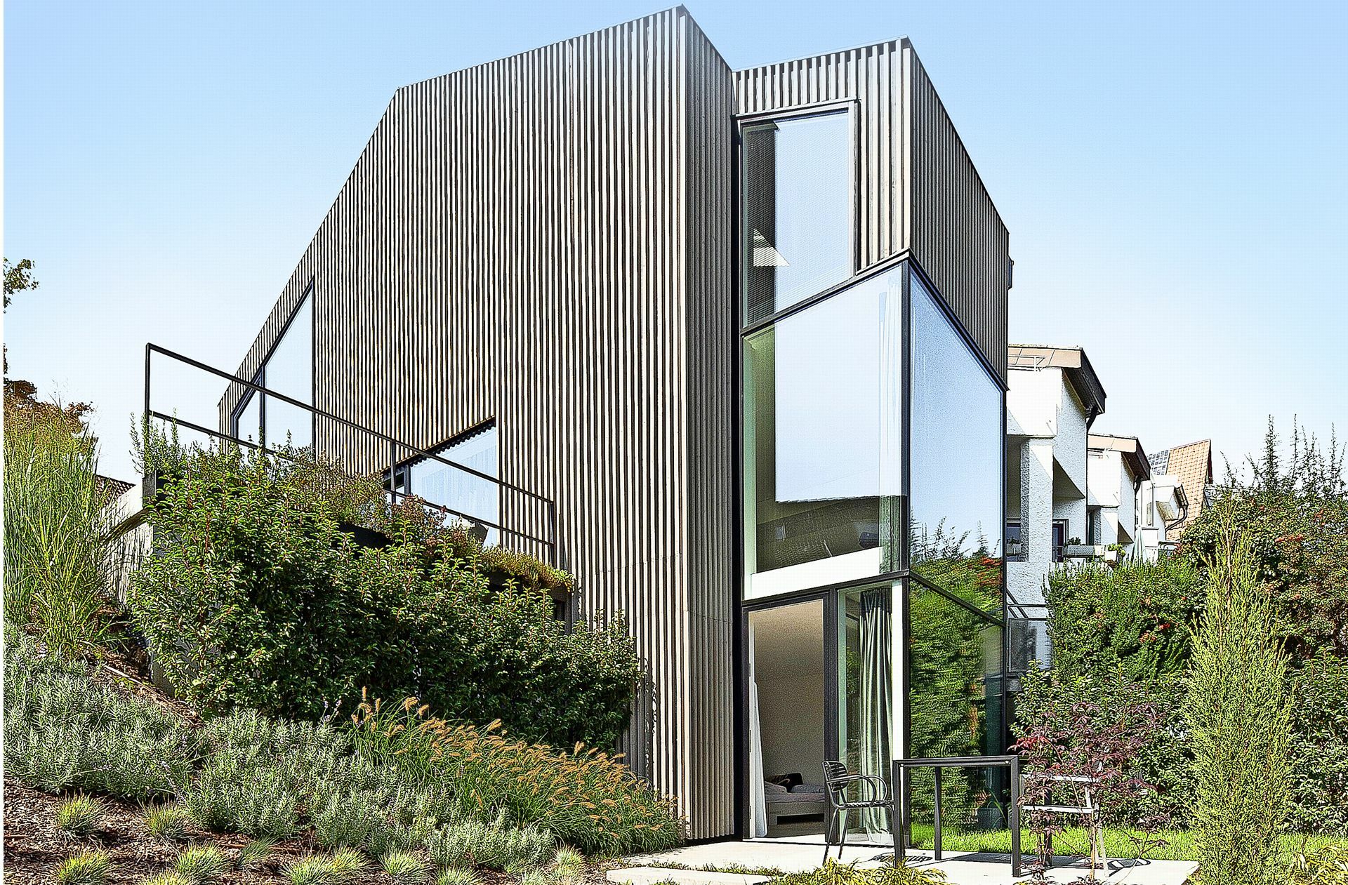 Tanzt mit einer vertikalen Holzlamellen-Fassade schick aus der Reihe: Umgebautes Reihenendhaus in Stuttgart Uhlbach.
 Foto: Thomas Sixt Finckh/FINCK..