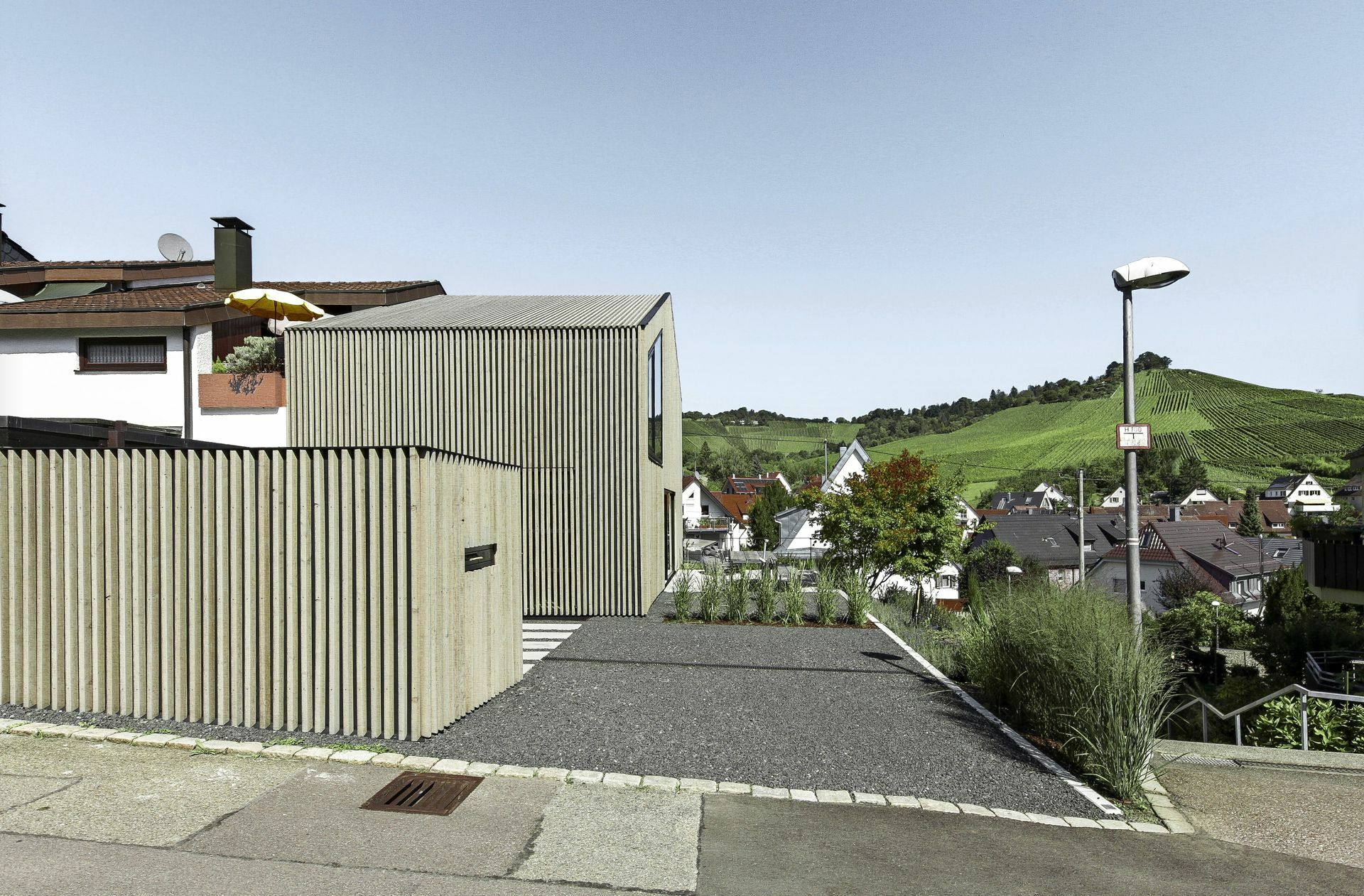 Nach dem Umbau. Das Haus wurde mit vertikalen Holzlamellen versehen. Vor dem Haus ist eine Box, die Platz bietet für Dinge, die sonst oft im Keller oder auf dem Dachboden verstaut werden. Zudem haben die Bauherren so eine Art Patio, die Sichtschutz vor Passanten bietet.
 Foto: Thomas Sixt Finckh/FINCK..