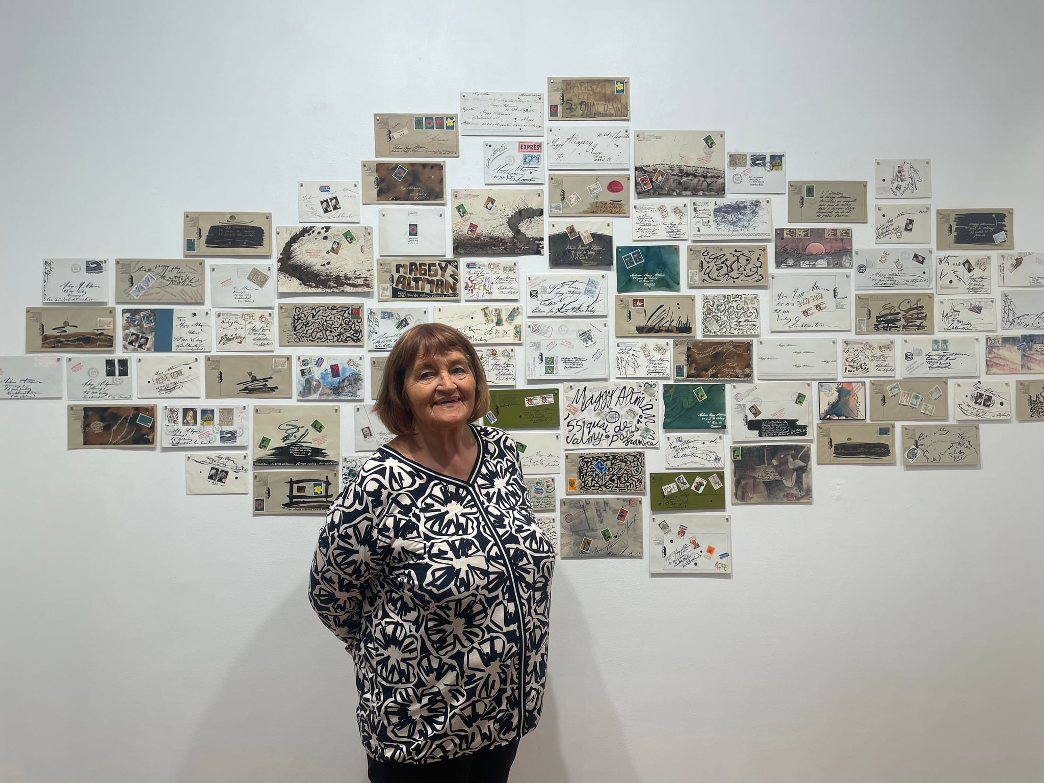 Maggy Mauritz vor der Wand mit den künstlerisch gestalteten Briefen von Roberto Altmann in Paris.