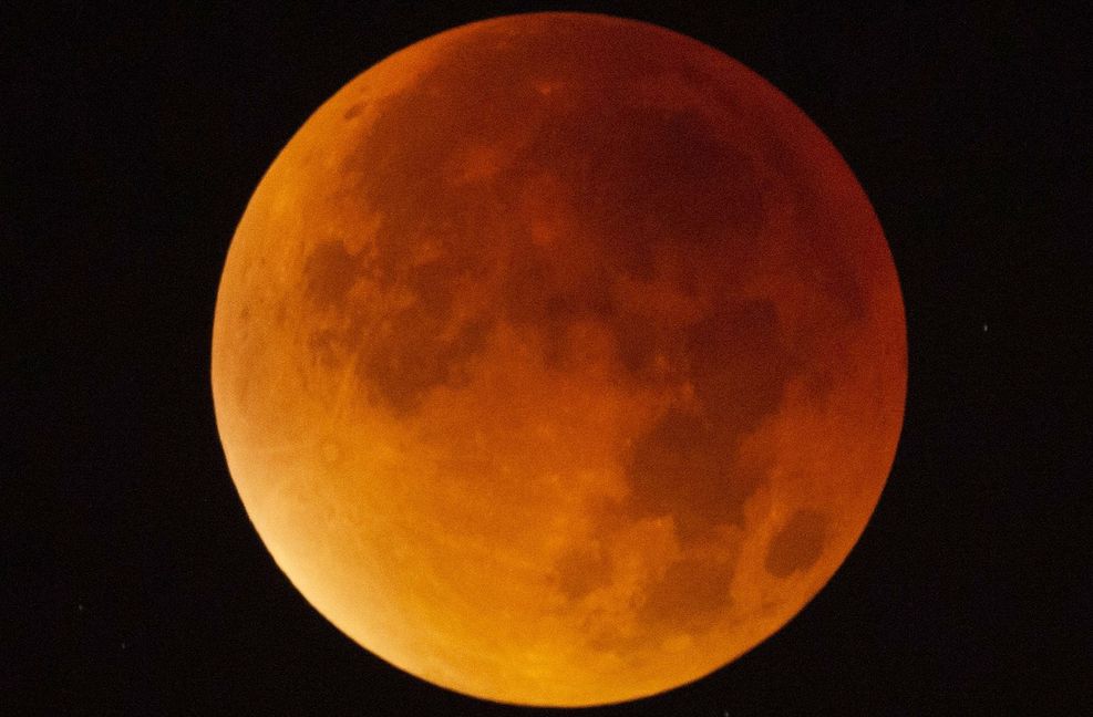 Der Mond erscheint am 21. Januar über Stuttgart während einer Mondfinsternis fast vollständig in einem rötlichen Farbton. Ursache des roten Schimmers sind die roten Anteile des Spektrums der Sonnenstrahlen, die durch die Erdatmosphäre in den Kernschatten der Erde abgelenkt werden.