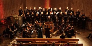 Der Kammerchor bei seinem Gloria-Konzert mit Solosopranistin Natalie Beck neben Dirigent Homolka.