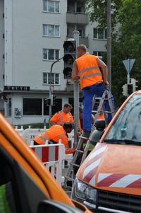 Stadtmitarbeiter erneuern die zerstörte Ampel.