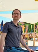 Bastian Schröter von der Hochschule für Technik beschäftigt sich mit dem Kühlbedarf Stuttgarts. Hier sitzt er unter einem Sonnensegel am Marienplatz.