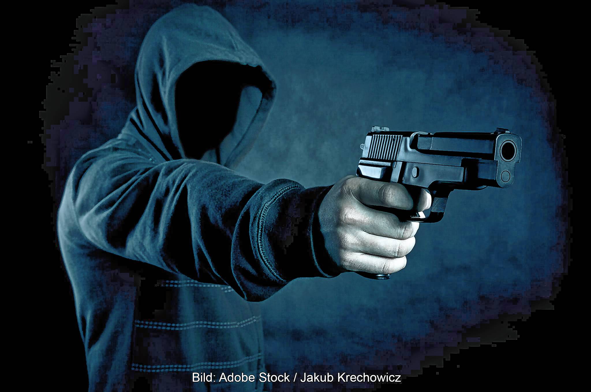 Der eine der beiden Täter zielte mit der Pistole durch die Glasscheibe der Tür.