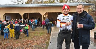 Bürgermeister Florian Glock (rechts) und Hannes Genze stoßen bei der Einweihungsfeier für die Blockhütte auf deren Wiederaufbau und auf Genzes Sieg beim Radrennen (die SZ/BZ berichtete) an.  Bild: Reichert