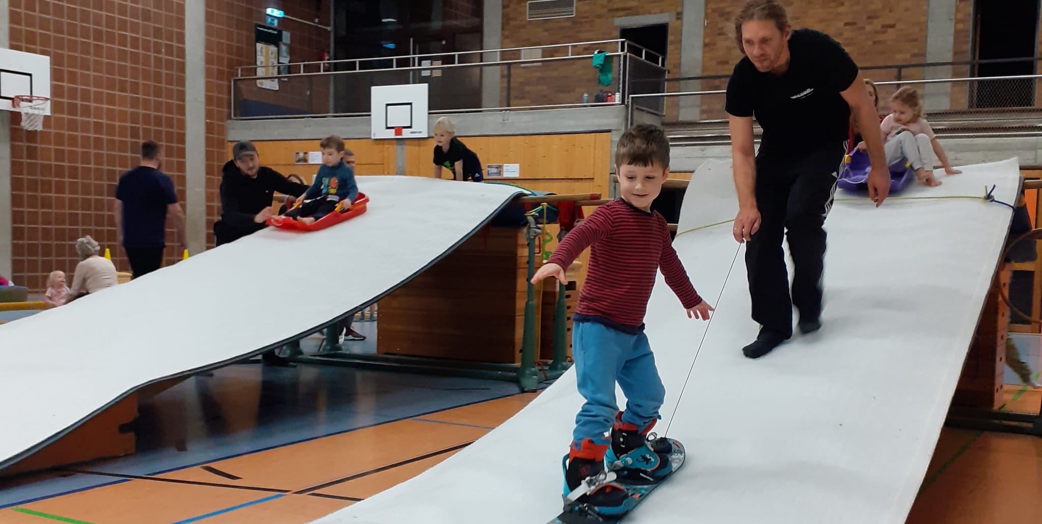 Mit dem Snowboard die Rampe runter.