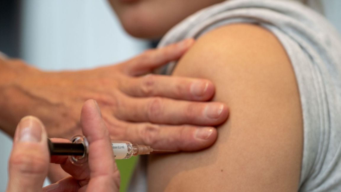 Eine Gynäkologin setzt bei der HPV-Impfung in einer Frauenarztpraxis eine Injektion in den Oberarm einer Jugendlichen.