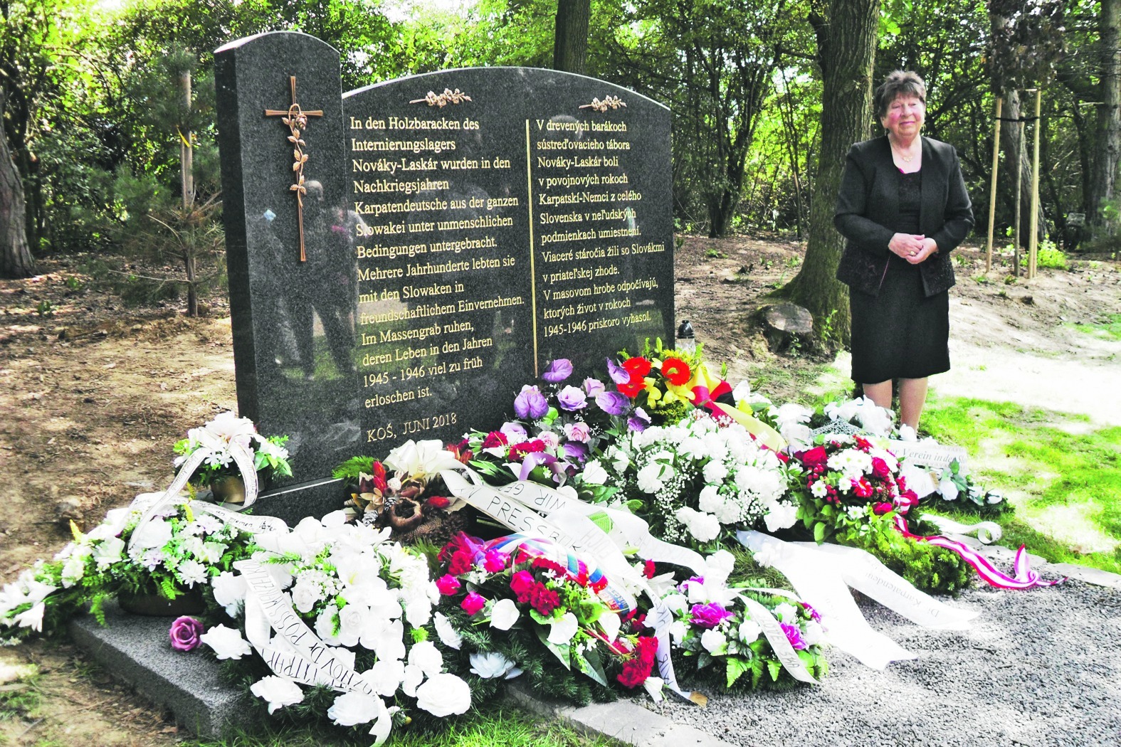Das Mahnmal für die karpatendeutschen Opfer im Lager Nováky und seine Initiatorin Anni Zjaba. Bild: Werner Laser